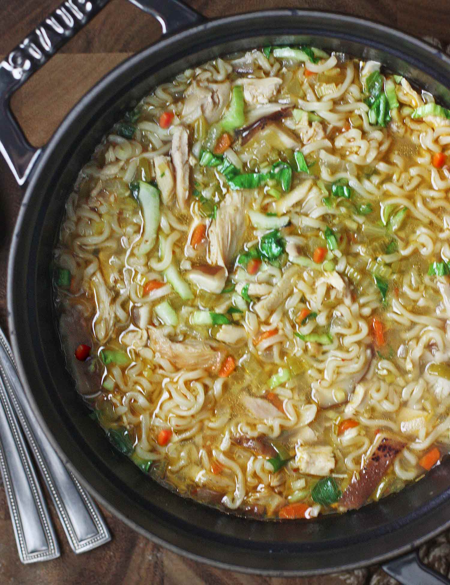 Thai Ramen Noodle Soup in a large soup pot with spoons to the side.
