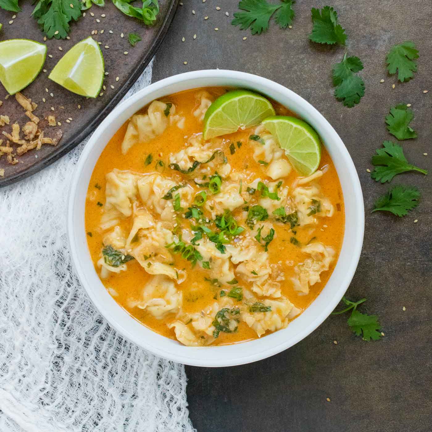 Overhead view of Thai Red Curry Dumpling Soup in a white bowl.