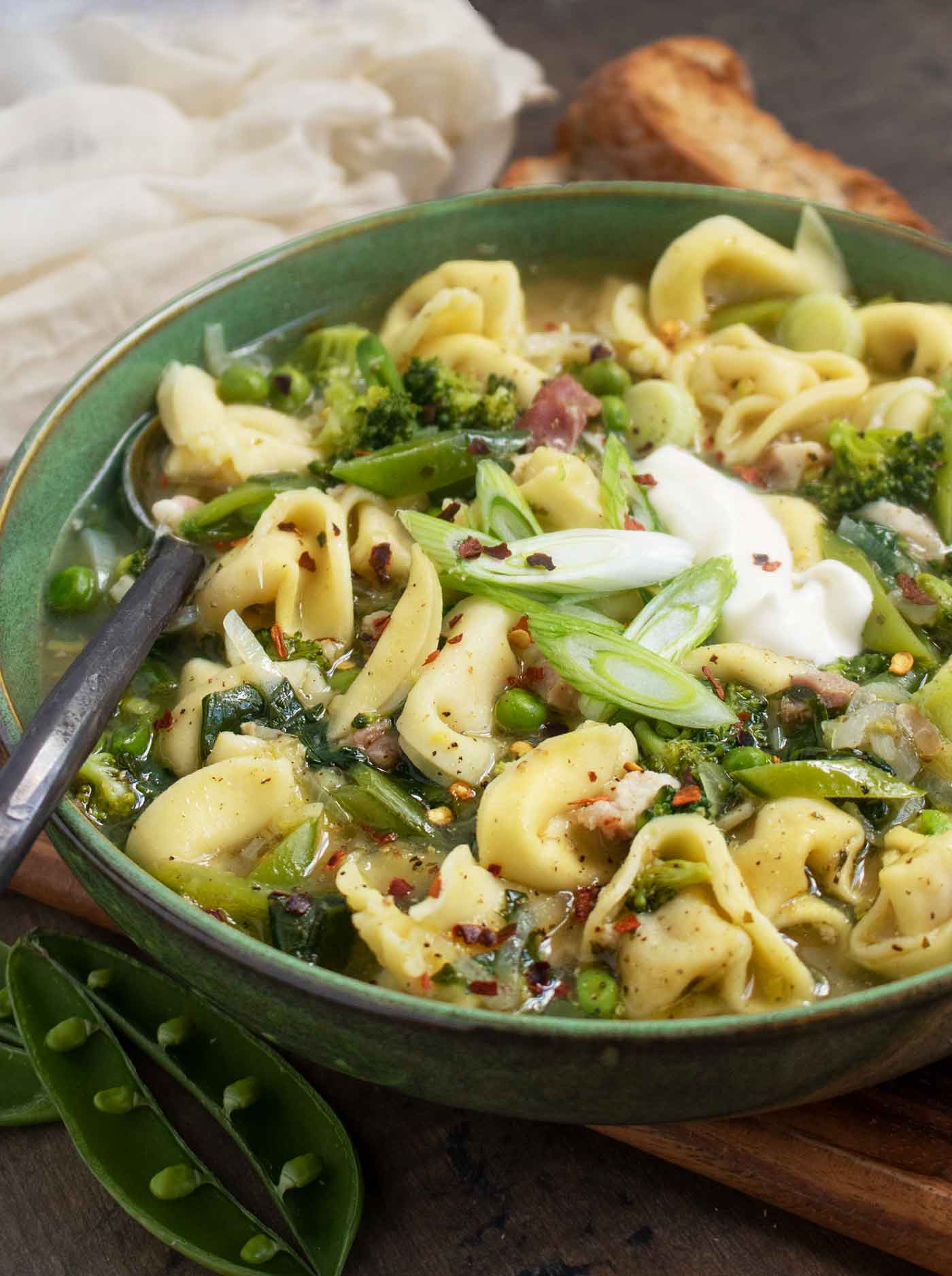 Side-angled view of a bowl of Tortellini Primavera Soup.