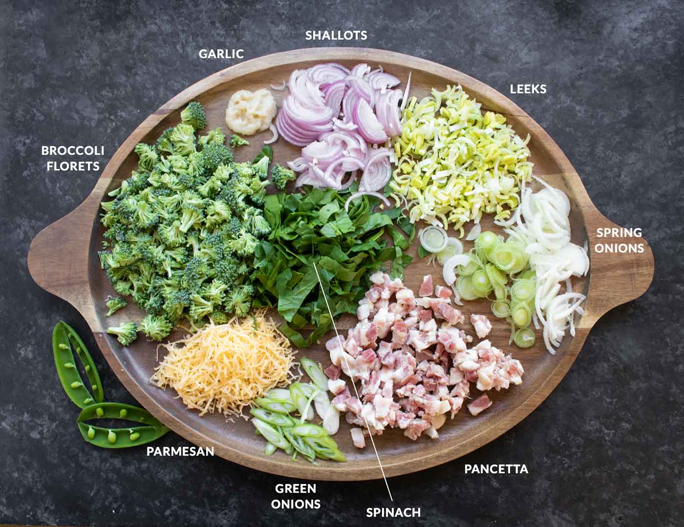 Prepped soup ingredients on a wooden serving tray.