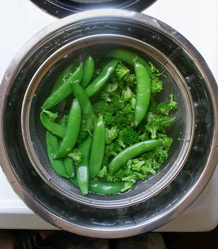Blanced broccoli and sugar snap peas chilling out in iced water.