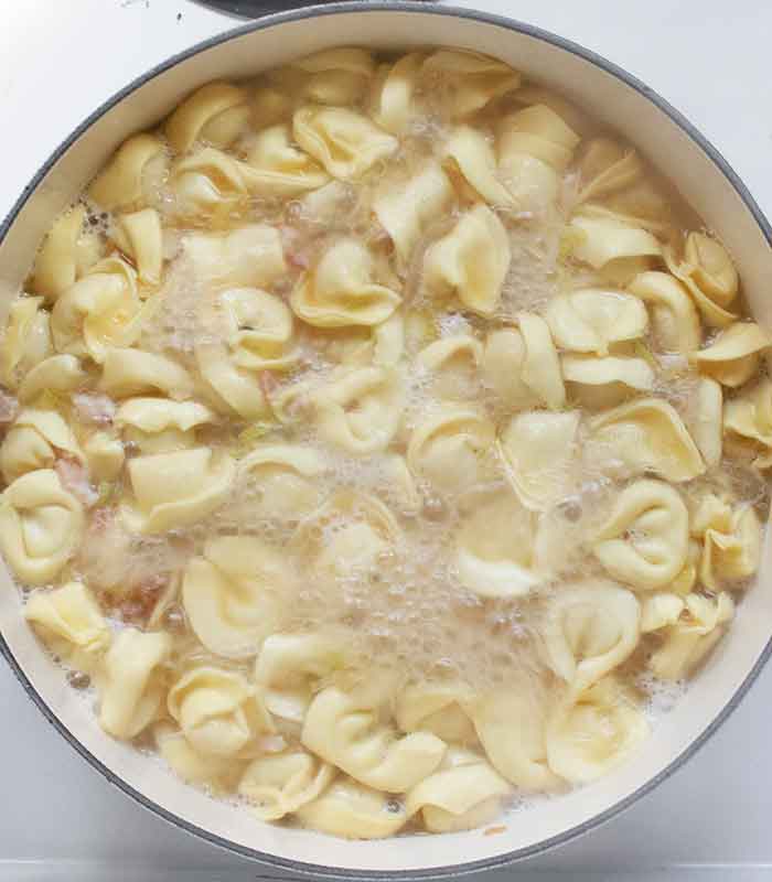 Tortellini cooking in the soup broth.