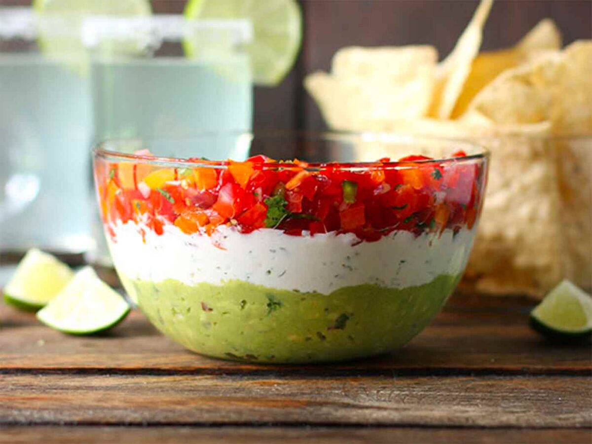 Triple Layer Guacamole Dip in a clear bowl so you can see the beautiful layers.