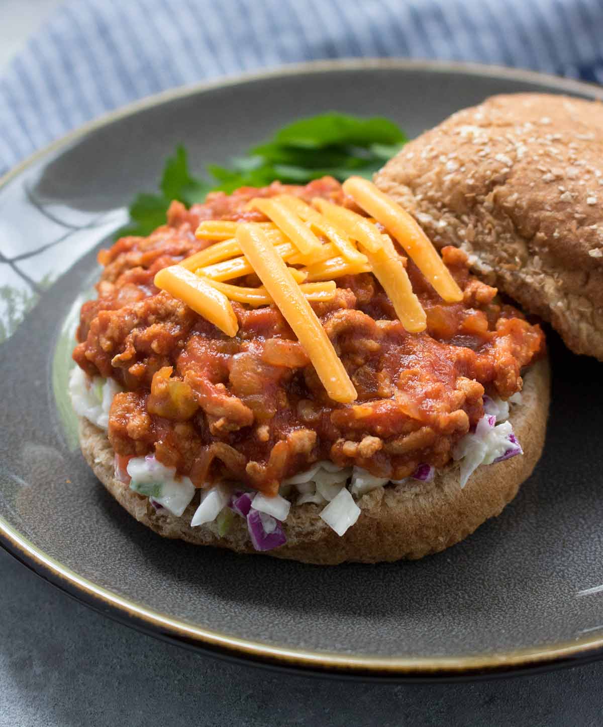 Open-faced Turkey Sloppy Joes with super-sharp cheese and coleslaw on a bun. Recipe at SoupAddict.com