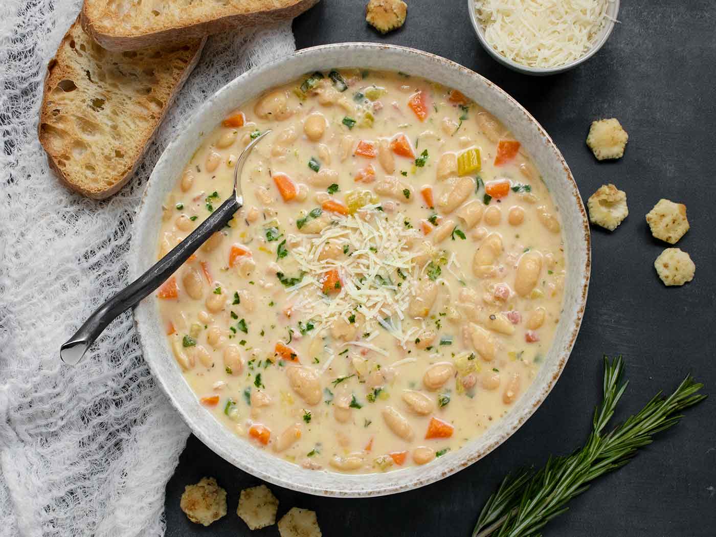 Overhead view of a bowl of Tuscan White Bean Soup with a spoon.