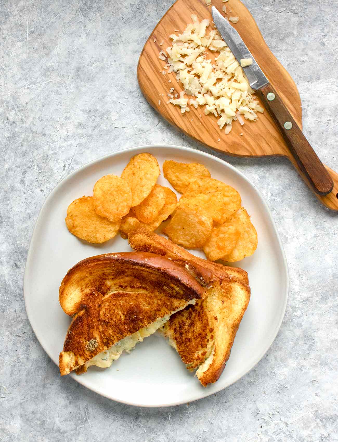 Ultimate grilled cheese sandwich on a plate with potato chips