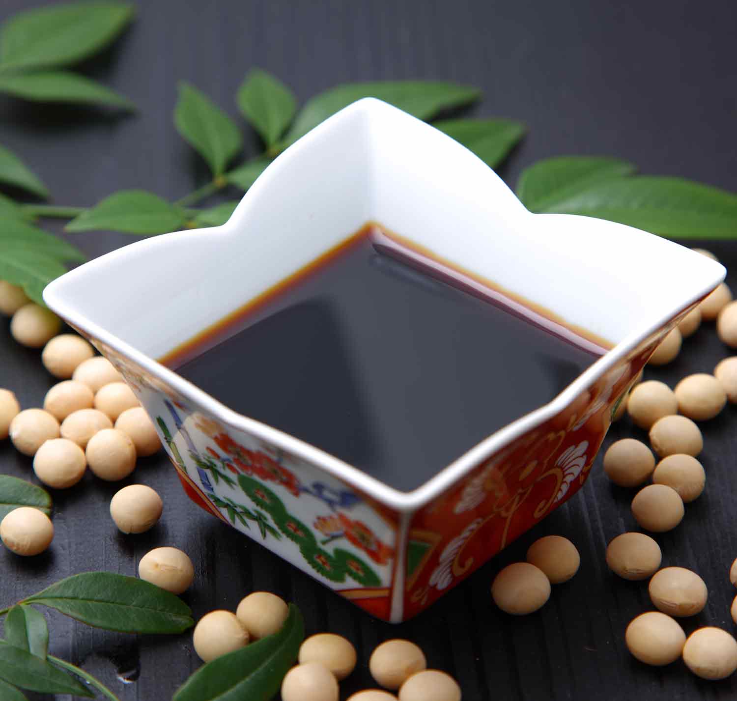 Soy sauce in a square white bowl.