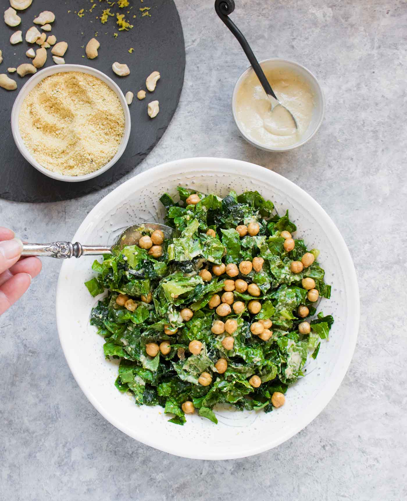 Tossing vegan caesar salad in a bowl
