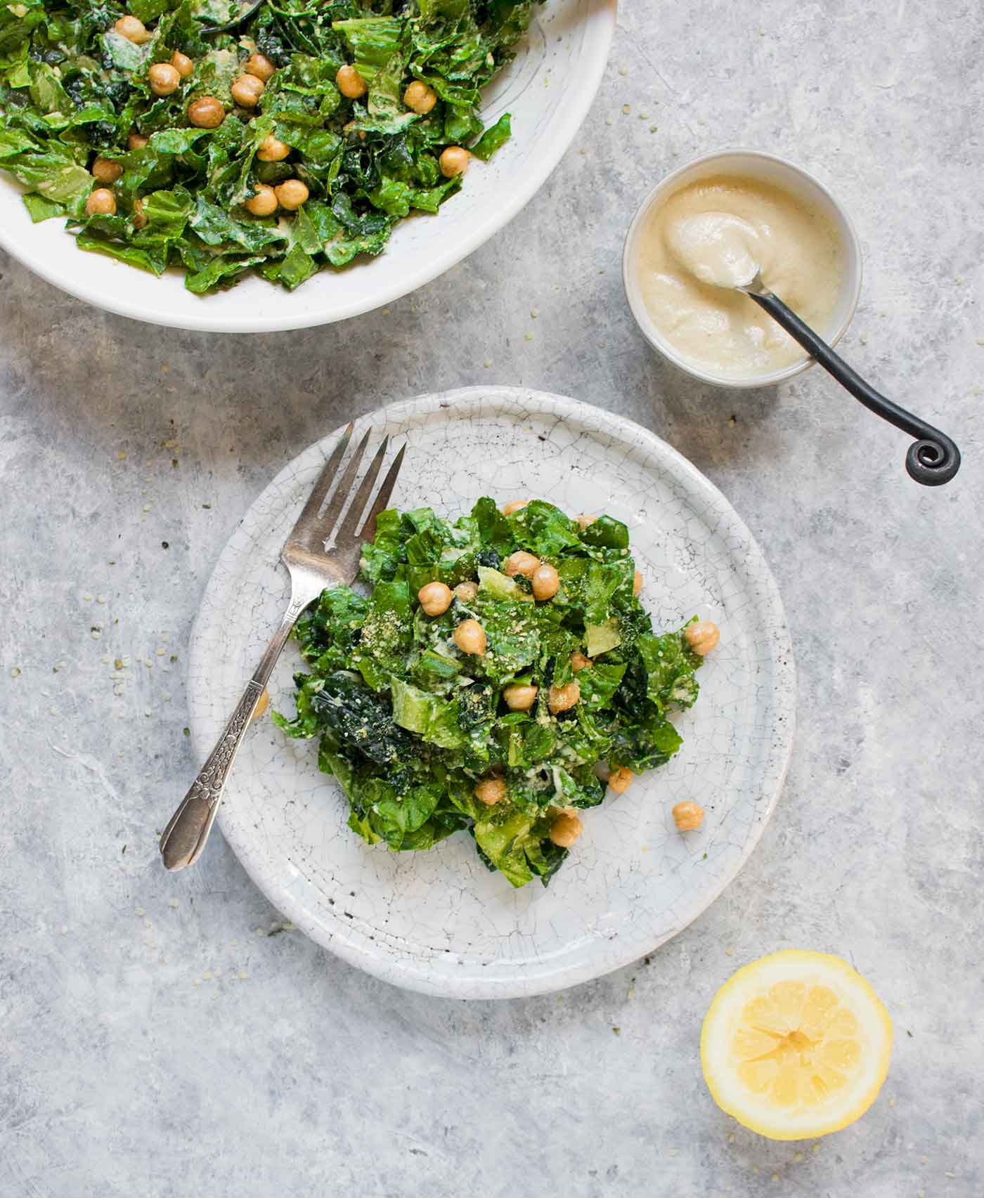 Vegan Caesar Salad on a plate with a side of vegan caesar dressing