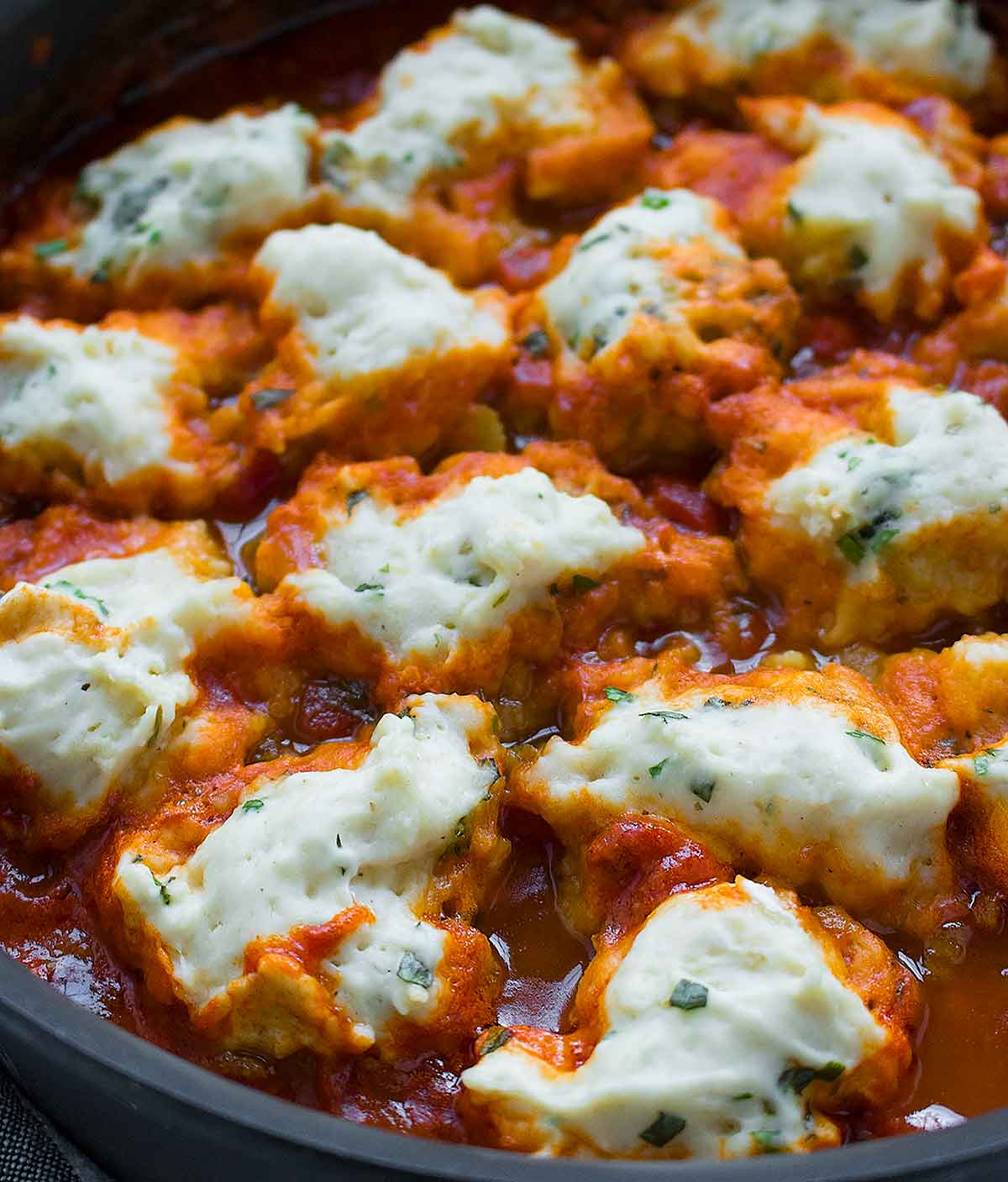 Vegan dumplings cooking in vegetable soup.