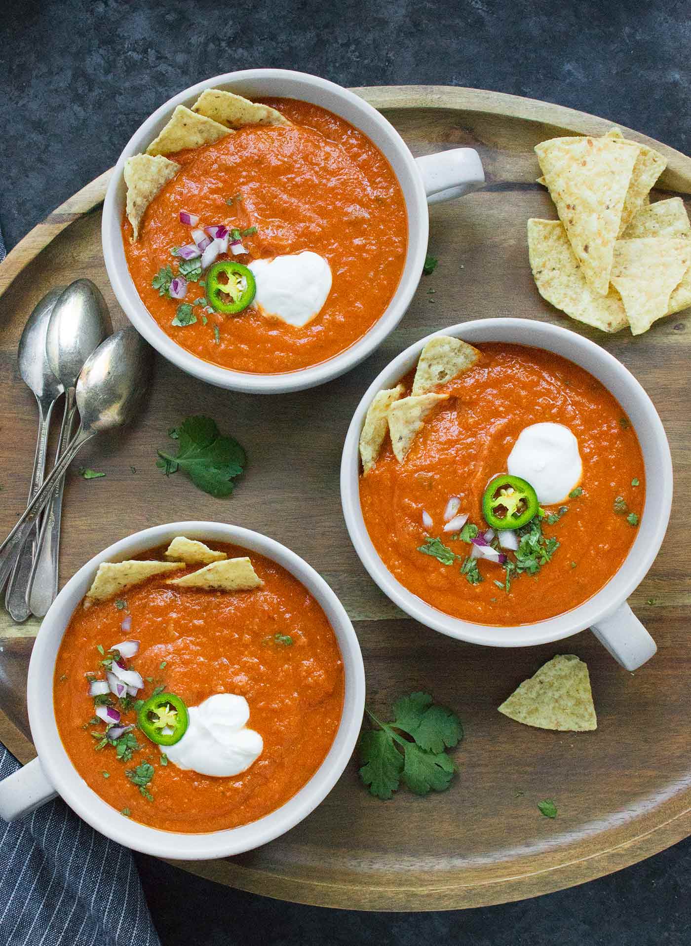 Three bowls of Vegetarian Tortilla Soup on a wooden serving tray